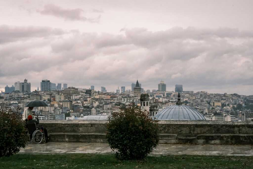 A scenic rainy view from a rooftop in Istanbul, overlooking the city and iconic Galata Tower.